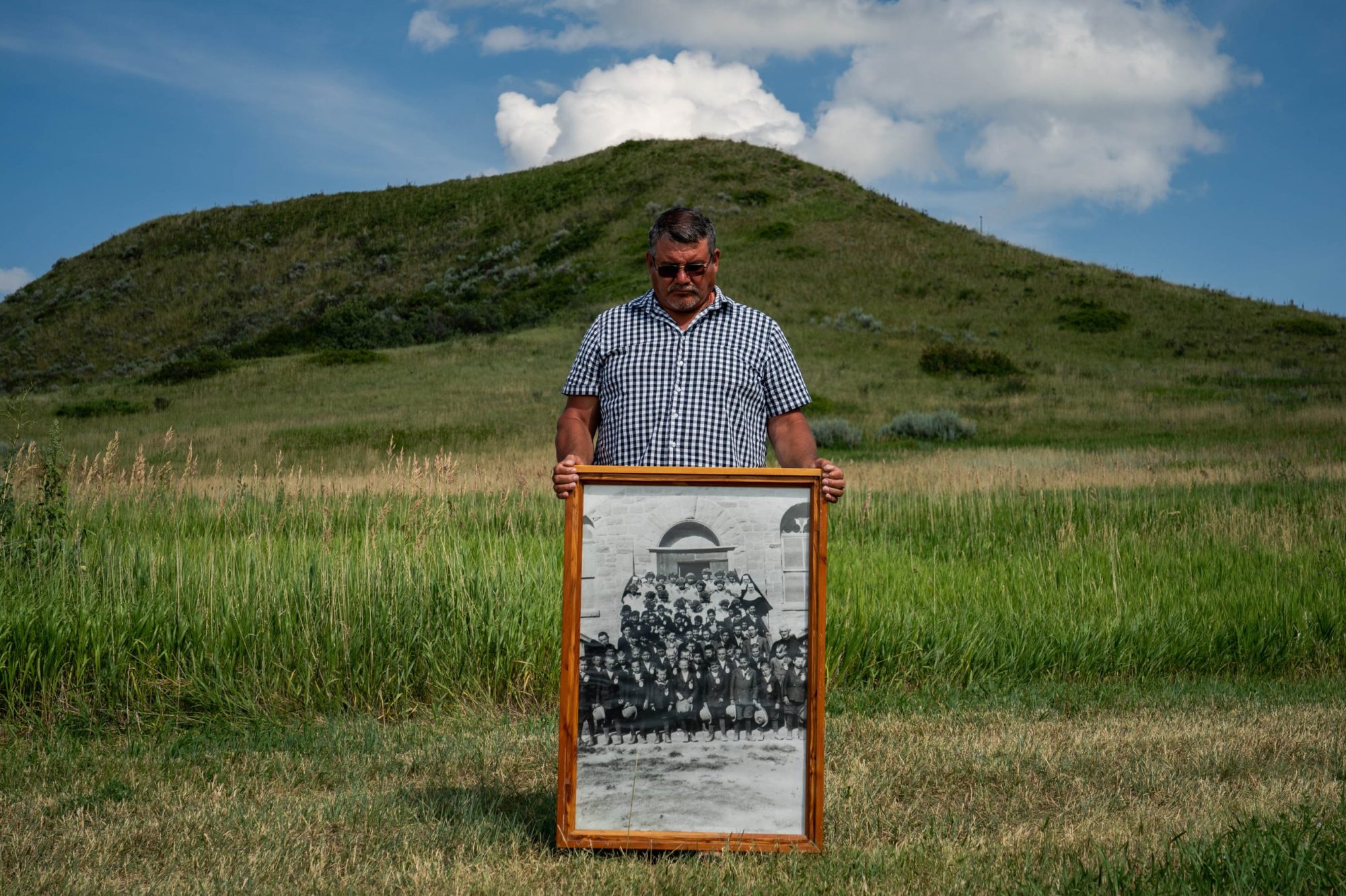 Warren Morin, 59, a member of Gros Ventre and Assiniboine tribes, holds a framed photo of his grandfather and other family members attending St. Paul's Mission boarding school as children on the Fort Belknap Reservation in Lodge Pole, Montana, Wednesday, July 12, 2023. Photo by Salwan Georges/The Washington Post via Getty Images