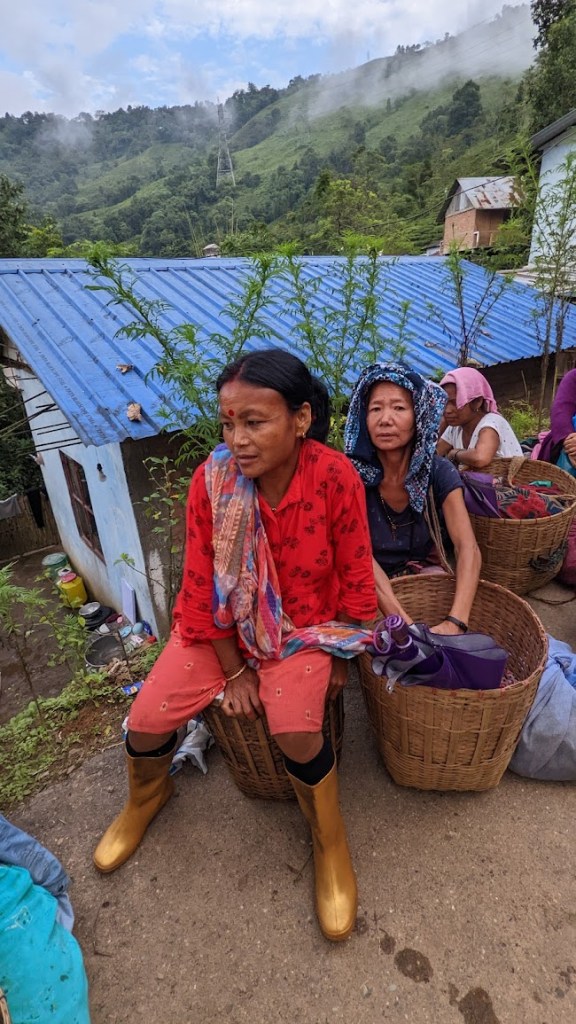 Women tea workers sit on or near their tea baskets outside on the Chongtong Tea Estate in Darjeeling, India, on October 13, 2022.