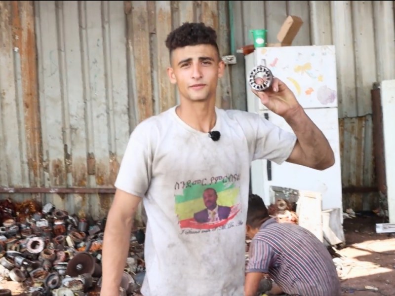 A worker at an e-waste recycling factory in Idhna, West Bank, shows a piece of electronic waste. Screenshot taken from video by Ahmad Al-Bazz